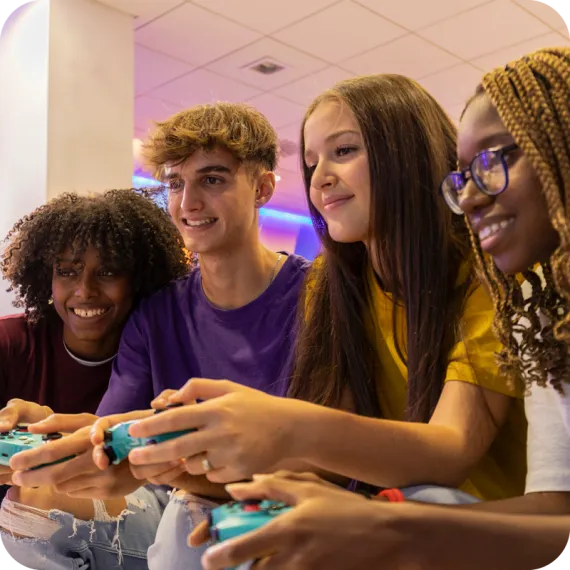 A diverse group of teens plays a video game together.