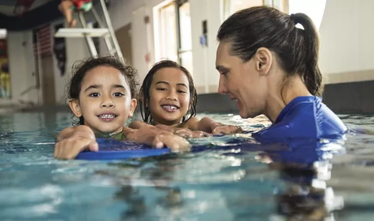 girls with swim instructor in pool