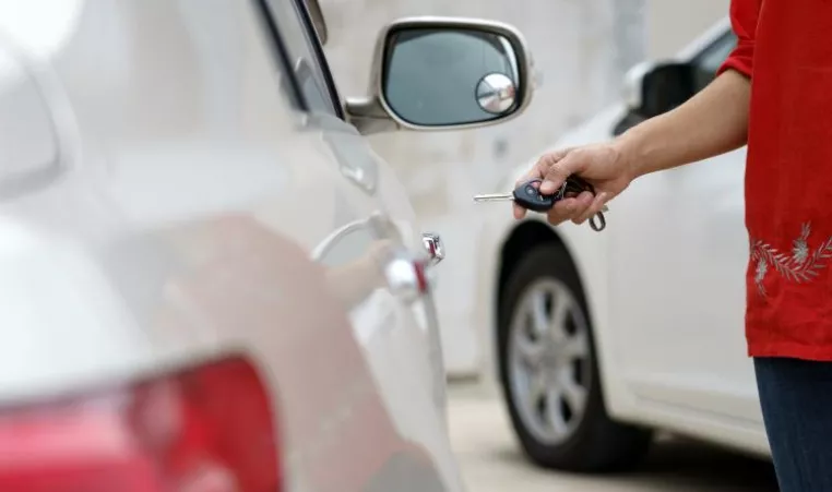 person unlocking car with key