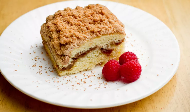 coffee cake on plate with raspberries