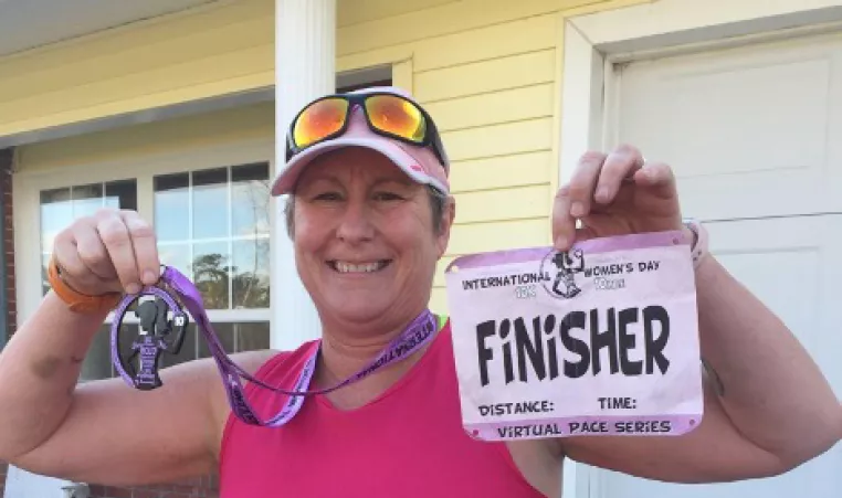 Tommiann Hill, a LIVESTRONG at the Y participant, with finisher race bib.