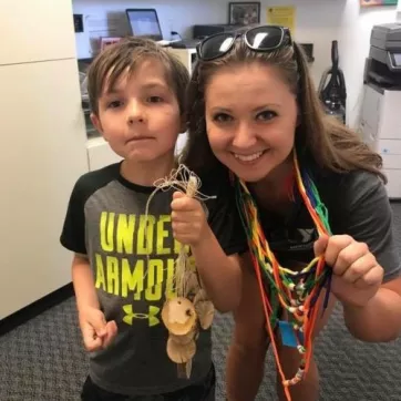 camp counselor with camper doing crafts