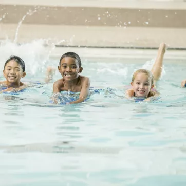 Children swimming together in a pool.