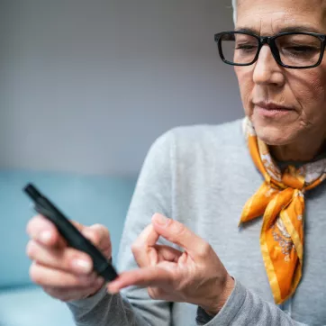 Woman doing diabetes blood test at home