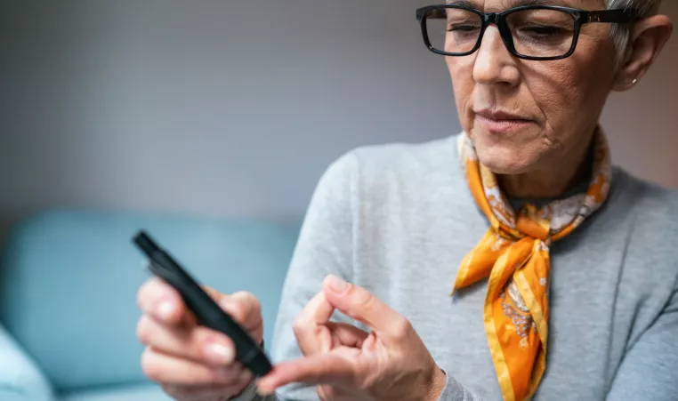 Woman doing diabetes blood test at home