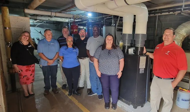 Weil-McLain and Eden Family Y staff in front of new boiler. 