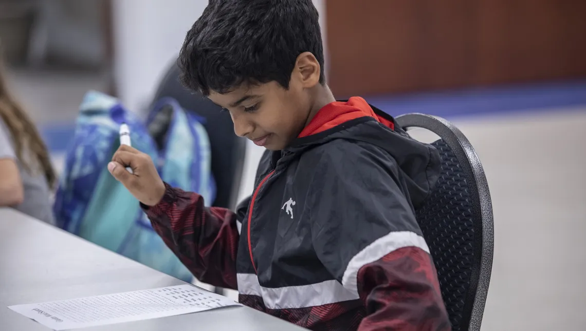 A young boy at the Ragsdale YMCA's afterschool program works on homework.