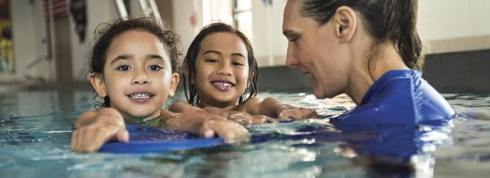 girls with swim instructor in pool