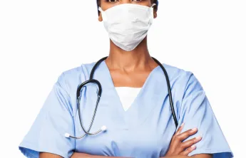 A doctor standing with her arms crossed.