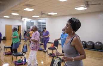 A SilverSneakers group exercise class at the Hayes-Taylor Y. A group of women are in a group exercise room.