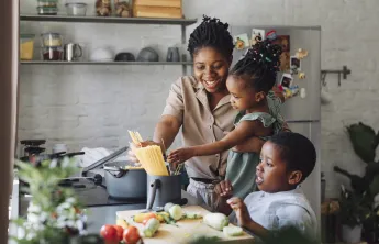 A family cooking together in the kitchen.