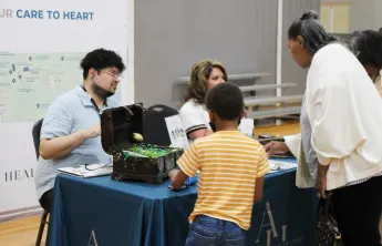 Community members connect with a vendor at an information booth during the Senior Expo at the Ragsdale YMCA, highlighting resources and engagement for older adults and families.