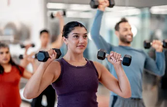 A woman using hand weights in a group exercise class.