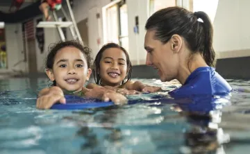 girls with swim instructor in pool