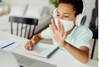 child waving during remote learning on screen