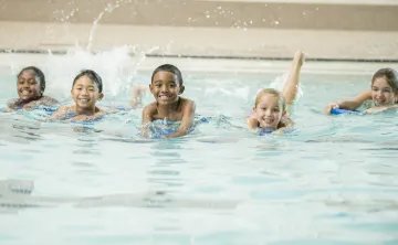 Children swimming together in a pool.