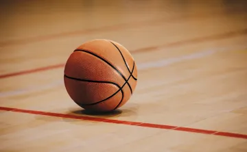 A basketball on a gymnasium floor.