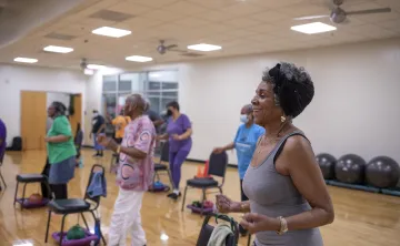 A SilverSneakers group exercise class at the Hayes-Taylor Y. A group of women are in a group exercise room.