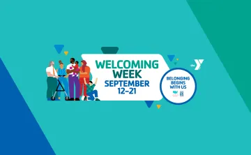 A background made of blues and greens with a white YMCA logo and 3 small yellow triangles among blue and green triangles. An illustration of a diverse group of people stands at the left side of the image. The center of the image reads "Welcoming Week" in medium and dark green, and "September 12-21" in dark blue. On the right side of the image, a white circle with a dark blue border holds the words "Belonging Begins with Us" in dark blue text.