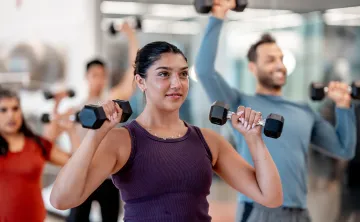 A woman using hand weights in a group exercise class.