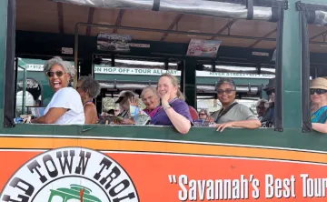 Members of the YMCA on a trip, participating in a Trolley ride smiling and waving