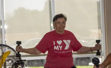 Women happily working out with weights in a SilverSneakers class