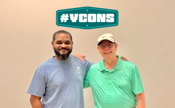 Two gentleman smiling for a photo with the graphic YCON above them