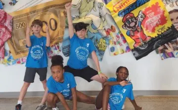 Group of children posing in front of a artistic wall 
