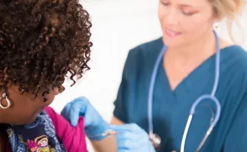 Nurse giving a woman a vaccine shot