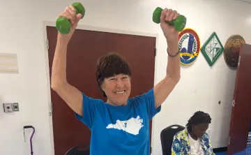 Women smiling holding weights over her head